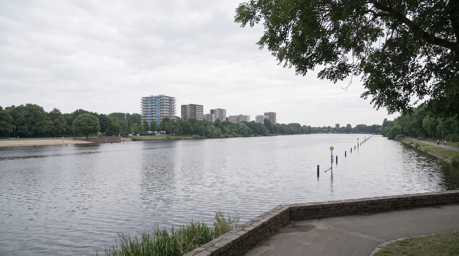 Uitzicht over het water in Amsterdam Nieuw-West met woontorens en groen langs de oever